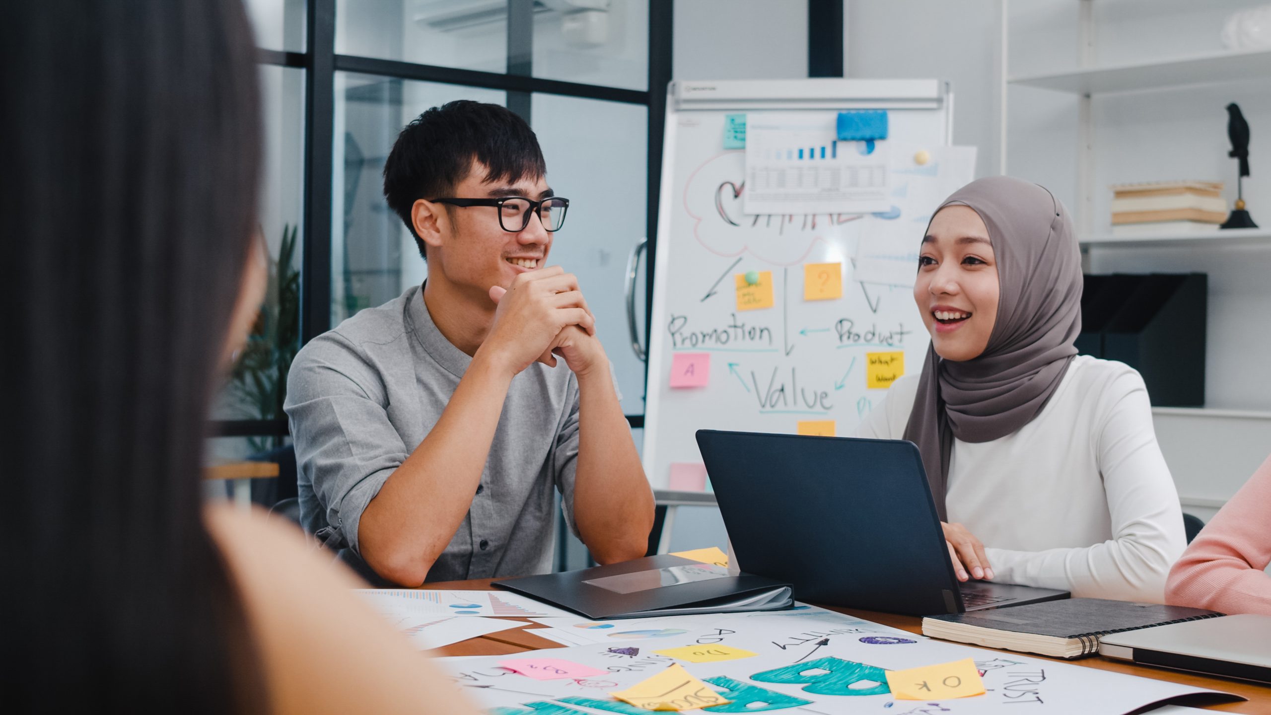 Multiracial group of young creative people in smart casual wear Multiracial group of young creative people in smart casual wear discussing business brainstorming meeting ideas mobile application software design project in modern office. Coworker teamwork concept.